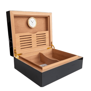 Vista lateral del interior de un humidor negro con división de madera clara y higrómetro incorporado.